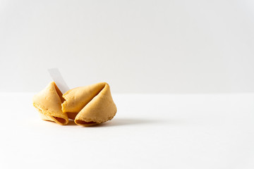 Two fortune cookies on a bright white background with a blank space for a fortune and copy space