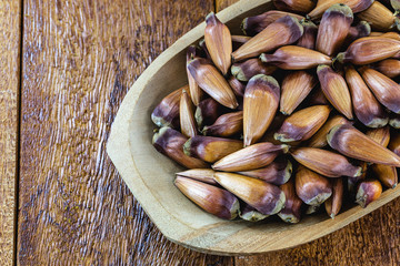 Typical araucaria seeds used as a condiment in Brazilian cuisine in winter. Brazilian pine in rustic brown wooden bowl. Calling from Pinhão in Brazil