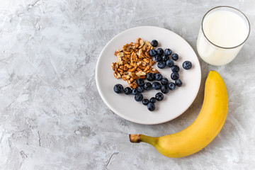 Healthy breakfast / lunch, blueberry, walnut, banana, glass of milk on cement background. healthy food. Proper nutrition