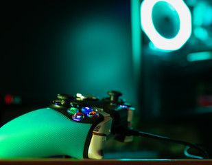 Game pad and a glass pc case with turquoise lighting © Gabriele Maltinti