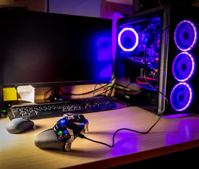 Game pad on a wooden desk with glass pc case © Gabriele Maltinti