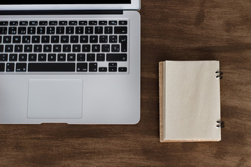 laptop on a wooden table with old agenda