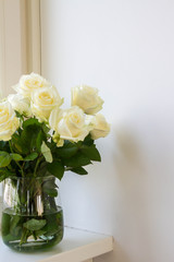 White roses in glass vase.