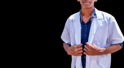 Cropped shot of an unrecognizable male doctor standing with hands holding a white coat with black background