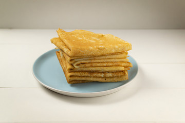 Pancakes (Russian Blini) with strawberry jam and tea on a white background. Breakfast. Сlose up.