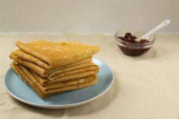 Pancakes (Russian Blini) with strawberry jam and tea on a white background. Breakfast. Сlose up.
