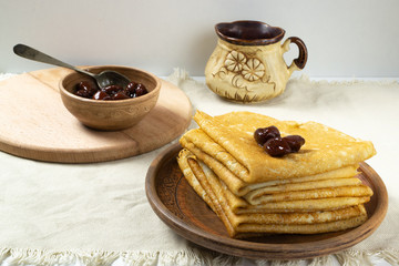 Pancakes (Russian Blini) with strawberry jam and tea in a rustic style. Breakfast. Сlose up.