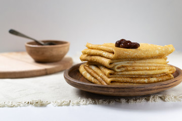 Pancakes (Russian Blini) with strawberry jam and tea in a rustic style. Breakfast. Сlose up.