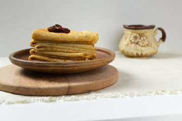 Pancakes (Russian Blini) with strawberry jam and tea in a rustic style. Breakfast. Сlose up.