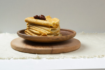 Pancakes (Russian Blini) with strawberry jam and tea in a rustic style. Breakfast. Сlose up.
