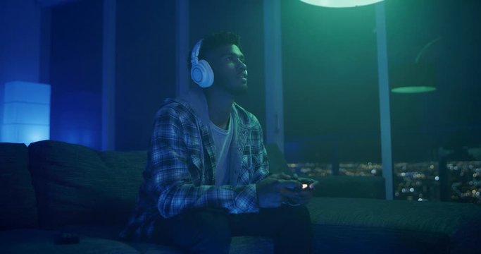 Man playing video games at night in apartment
