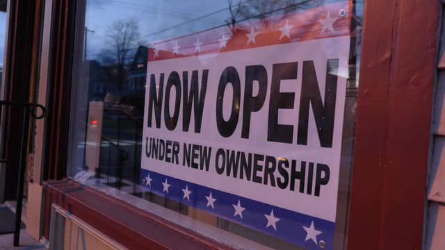 Now open under new ownership sign in window night time 