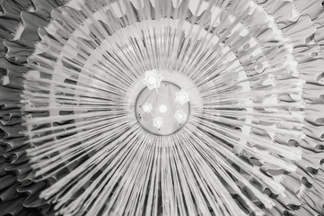 Light bulbs in a large round chandelier, black and white background
