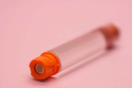 macro insulin cartridge on a pink background