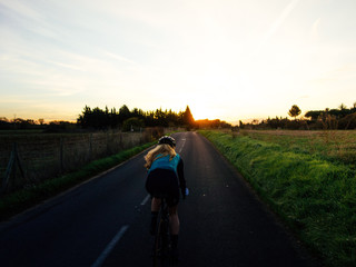 Cyclist in sunset light on bike path near the sea