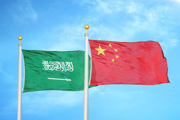 Saudi Arabia and China two flags on flagpoles and blue cloudy sky