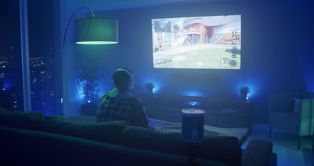 Man playing video games at night in apartment