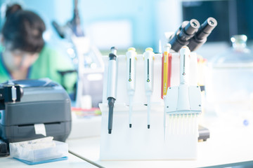 Automatic pipettes, female researcher professional. Work with microscope in research laboratory,...