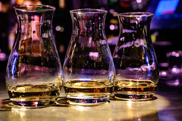 Flight of Scottish whisky, tasting glasses with variety of single malts or blended whiskey spirits on distillery tour in pub in Scotland