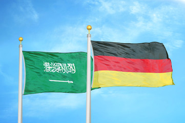 Saudi Arabia and Germany two flags on flagpoles and blue cloudy sky