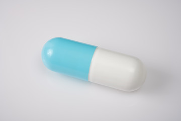 Large blue and white pill on white acrylic table