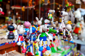 Obraz premium Wooden, colorful animals dog, mouse, giraffe, crocodile, beetle, hanging on black metal springs in market