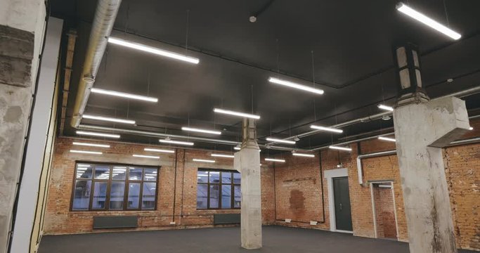 Empty modern loft interior with pillars and brick wall
