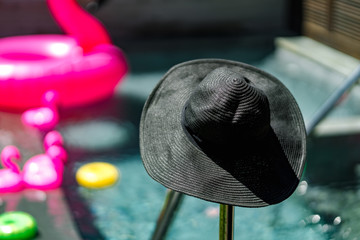 Black beach hats are sun-dried by the pool.