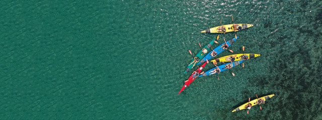 Aerial drone ultra wide photo of young athlete team practising sport canoe in tropical exotic bay...