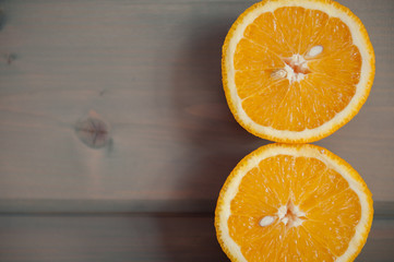 A bright juicy orange cut on a grey wooden background
