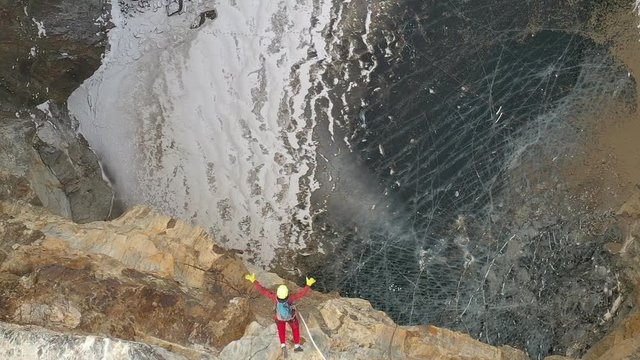 Aerial view of a man jumping into a canyon on a bungee. Slow motion.