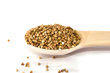 buckwheat in a wooden spoon on a white background. Copy space.