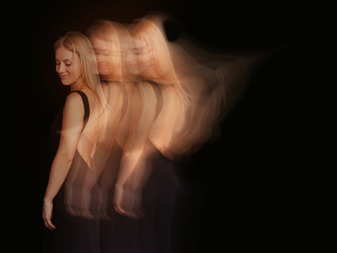 Portrait Of A Beautiful Young Blond Woman In Gold Light And Black Dress. Artistic Light Streak Effects.