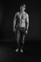 Fototapeta premium black and white studio shoot of strong athletic man on dark background