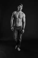 Fototapeta na wymiar black and white studio shoot of strong athletic man on dark background