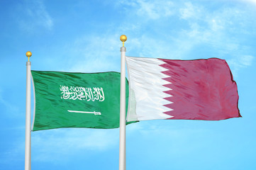 Saudi Arabia and Qatar two flags on flagpoles and blue cloudy sky