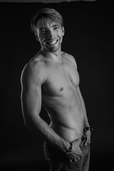 Fototapeta premium black and white studio shoot of strong athletic man on dark background