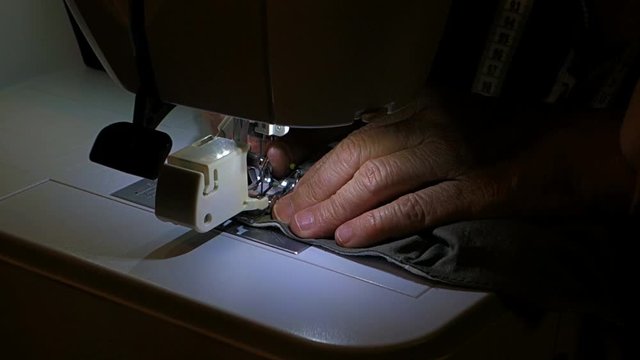 A tailor sews a medical mask at home to protect against coronavirus