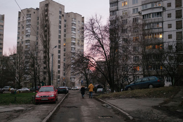 Two people walk down street in Kiev in pink sunset