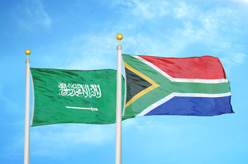 Saudi Arabia and South Africa two flags on flagpoles and blue cloudy sky