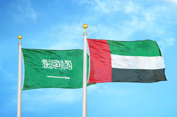 Saudi Arabia and United Arab Emirates two flags on flagpoles and blue cloudy sky