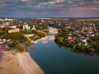 Beautiful evening top view of the river, city, central beach, churches, bridge. Bila Tserkva.