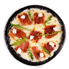 black pastry pizza with ham on a white plate for menu