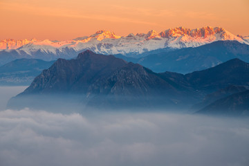 Fototapeta na wymiar Orobie Alps in the morning with fog during winter season, Lombardy, Italy.