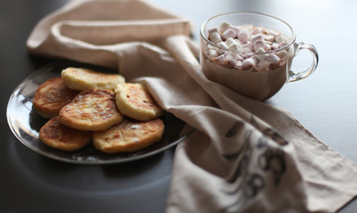Cocoa with marshmallows and cheesecakes