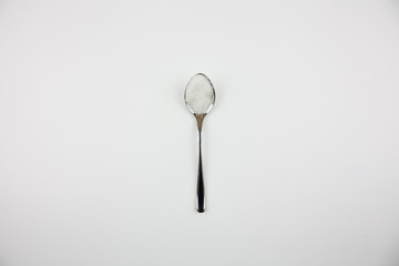 Iron small spoon with sugar on a white background