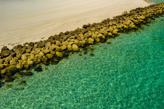 Rocks seperating ocean from beach sand