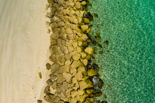 Aerial photo sand rocks and ocean water