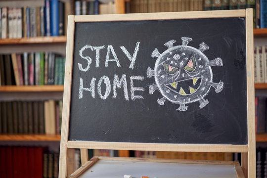 inscription stay at home. Outbreak Warning. written white chalk on blackboard in connection with epidemic of coronavirus worldwide.