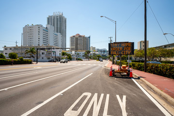Obraz premium Road sign on Miami Beach showing words stay home order for full city to slow spread of Coronavirus